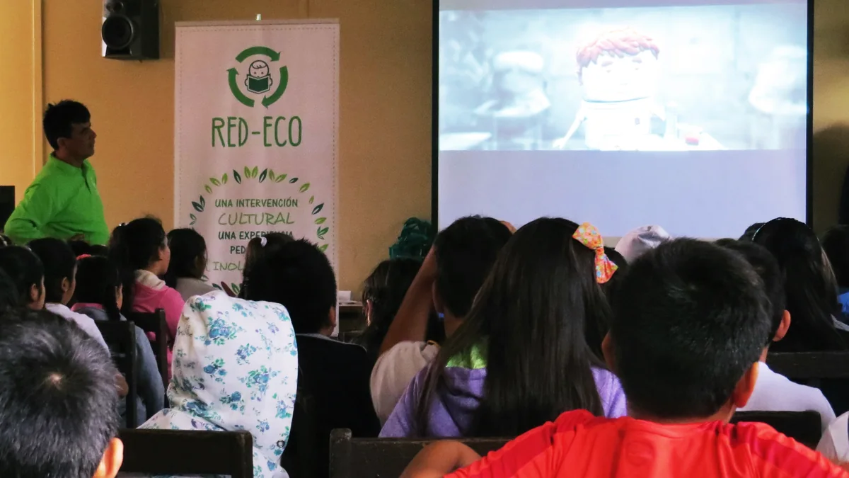 Inicio Expositor de RED ECO realizando una sesión educativa con estudiantes y una proyección.