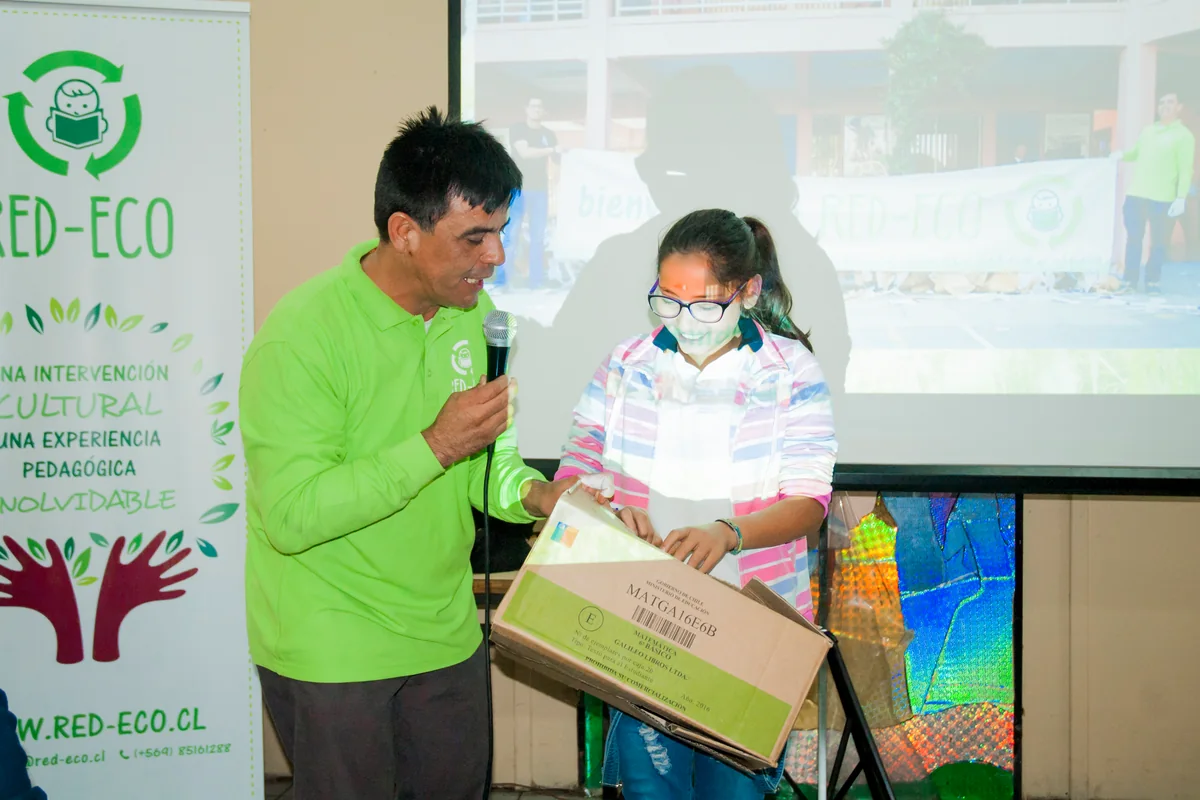 Expositor de RED ECO conversando con una estudiante durante una actividad.