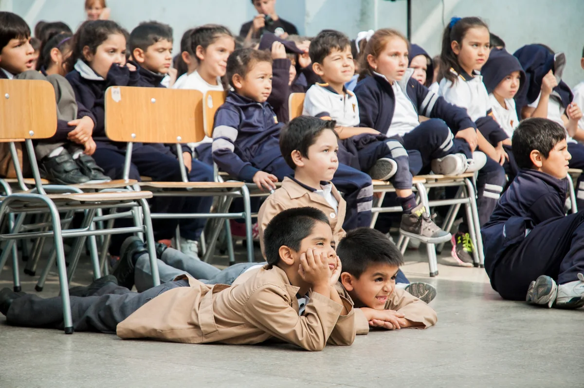 Grupo de estudiantes observando una actividad escolar.