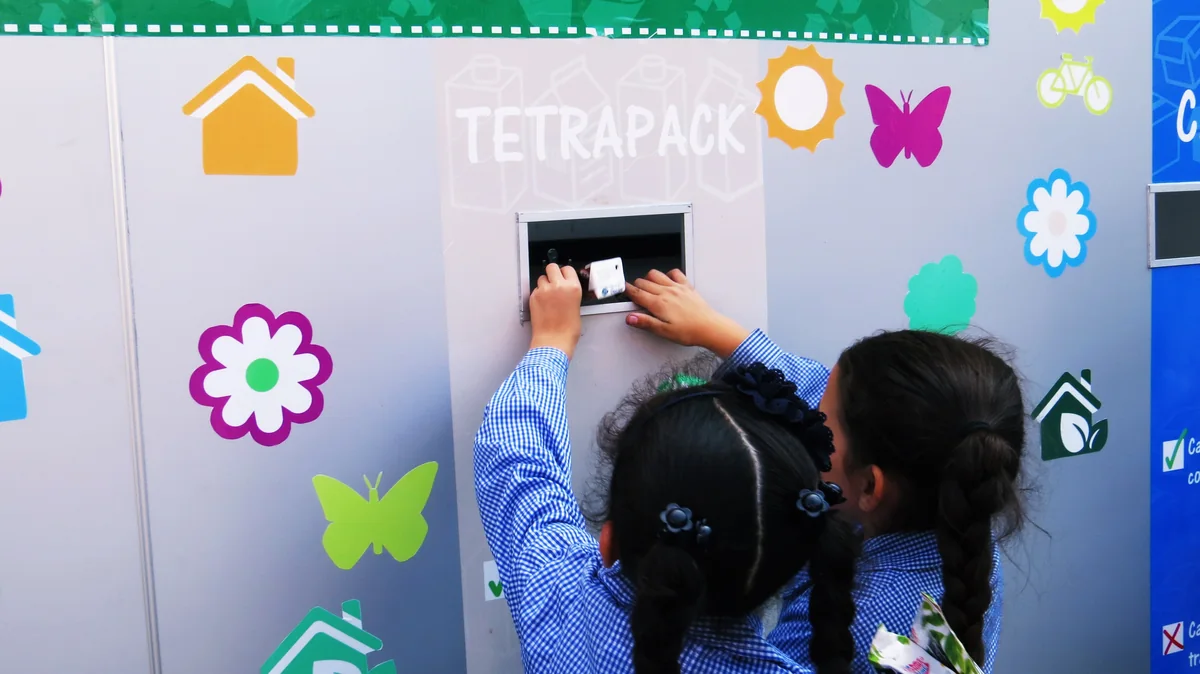 Inicio Estudiantes utilizando un punto limpio para separar residuos.
